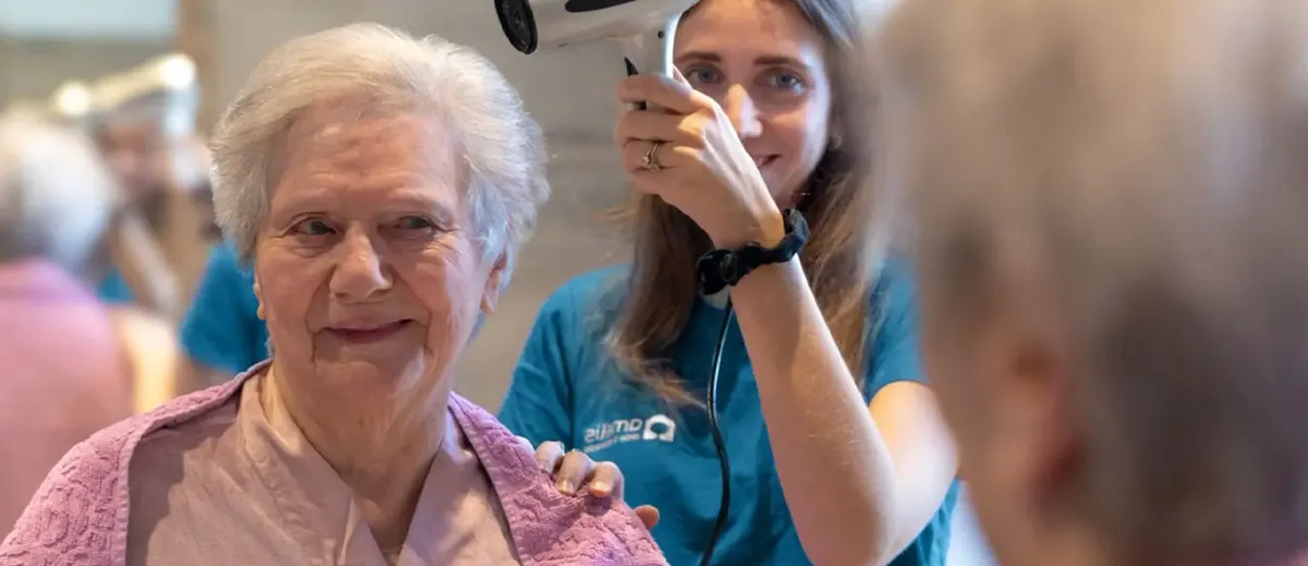 senior qui se fait aider par une auxiliaire de vie