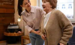 une dame de compagnie aide une personne âgée à se déplacer chez elle